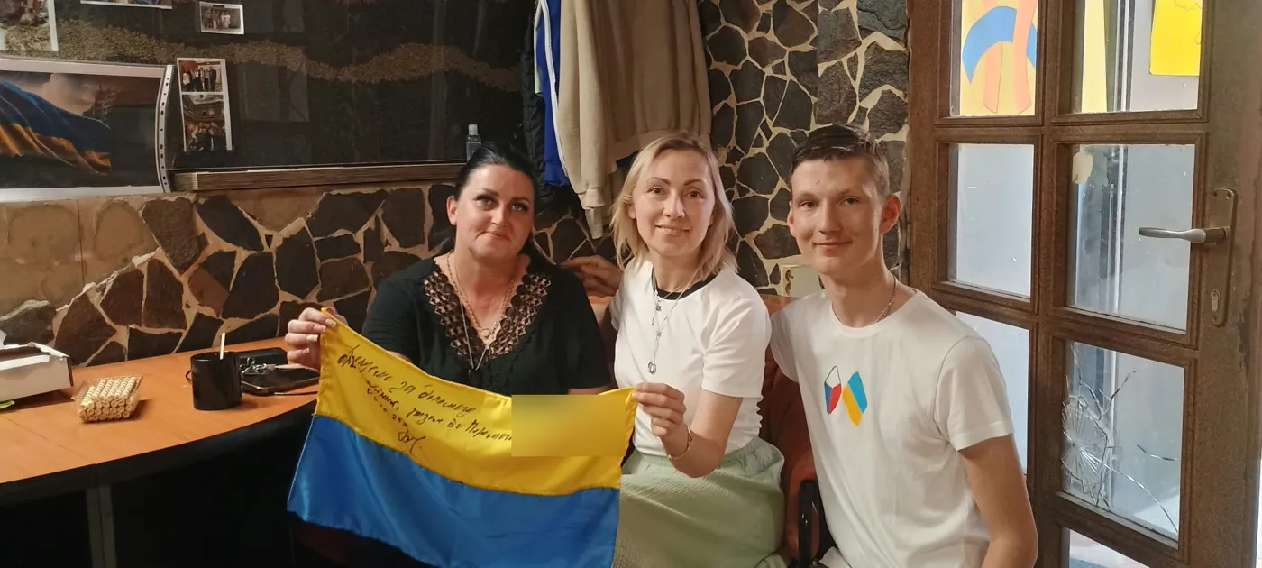 Maruška s dobrovolníky Spletinie a vlajkou s poděkováním od vojáků
